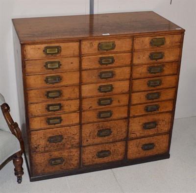 Lot 1130 - An early 20th century oak filing chest comprising twenty-four drawers, formerly from a printers...