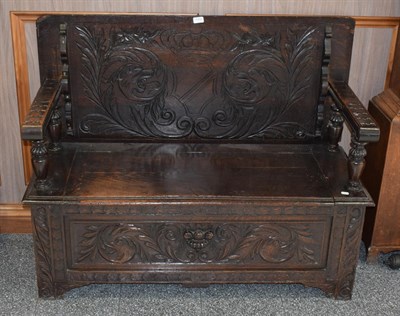 Lot 1154 - A 19th century carved oak monks' bench, with hinged seat and carved front panel