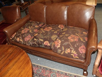 Lot 1190 - An early 20th century three-seater sofa, covered in brown close-nailed leather