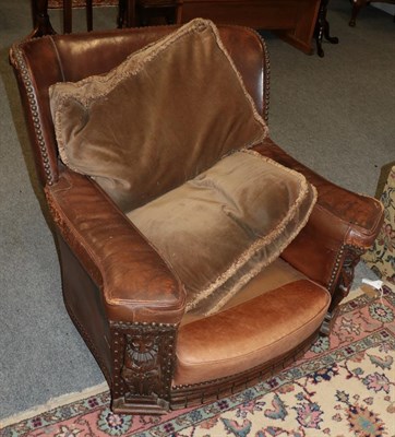 Lot 1192 - An early 20th century brown leather armchair, with carved arm supports