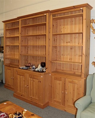 Lot 1212 - An impressive pine break front triple bookcase, 245cm high by 310cm wide by 57cm deep