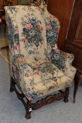 Lot 1225 - A 19th century wing back chair in William & Mary style, with floral loose cover, rounded arms...