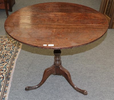 Lot 1229 - A George III oak tilt-top tripod table