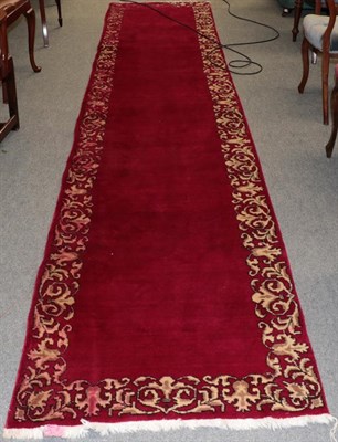 Lot 1290 - Tabriz runner, signed, the plain field enclosed by floral vine borders, 420cm by 86cm