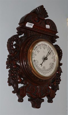 Lot 1296 - An Edwardian carved oak cased aneroid barometer