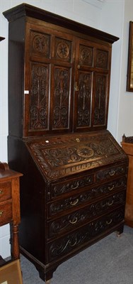 Lot 1306 - A carved oak bureau bookcase