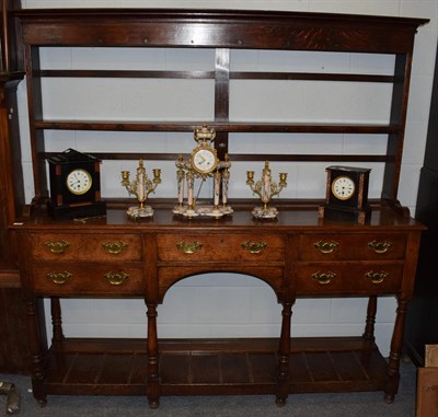 Lot 1307 - A George III oak open dresser, late 18th century, the rack with moulded pediment above a shelf, the