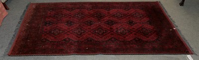 Lot 1348 - Afghan rug, the brick red field with two columns of medallions framed by multiple borders, 198cm by