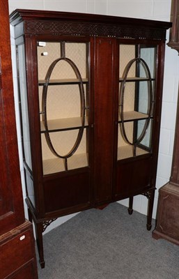 Lot 1370 - An Edwardian mahogany display cabinet, with blind fret carved frieze above glazed doors