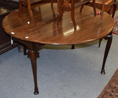 Lot 1394 - A George ll mahogany drop leaf dining table, the moulded edged oval top and arched frieze raised on