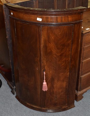 Lot 1398 - A George III mahogany bow fronted hanging corner cupboard