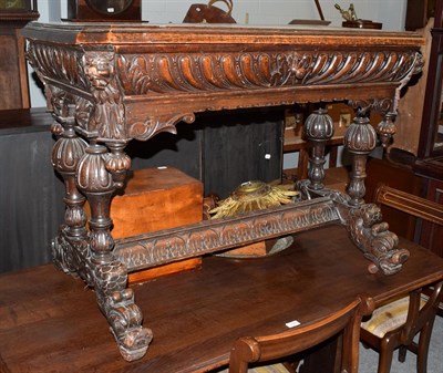 Lot 1441 - A carved oak side table with single drawer on four supports, joined by a stretcher with fish...