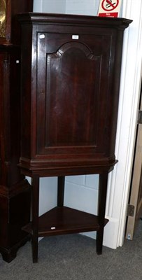 Lot 1447 - A George III oak corner cupboard on stand