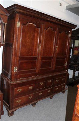 Lot 1453 - An 18th century joined oak clothes press cupboard, the moulded and dentil cornice above two...