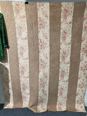 Lot 2174 - Early 20th century strippy quilt with dark cream and pink floral cotton stripes, cream reverse,...