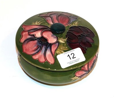 Lot 12 - Moorcroft Anemone powder bowl and cover on a green ground, with box