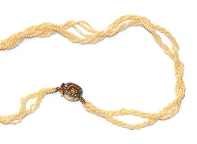 Lot 42 - A seed pearl necklace with a browny-orange stone and diamond set clasp, length 40.5cm