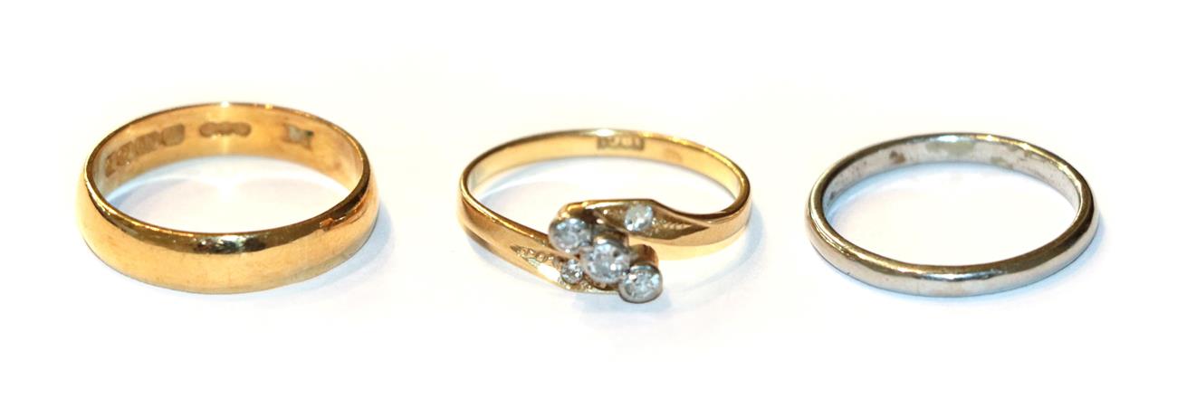 Lot 65 - A diamond three stone twist ring, stamped '18CT', finger size L; a 22 carat gold band ring,...