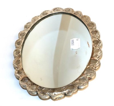 Lot 110 - A silver backed mirror stamped 925 AYHAN, decorated in repousse with a lotus blossom