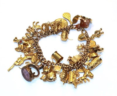 Lot 238 - A graduated charm bracelet, stamped '9' and '.375', hung with forty-five charms including a...