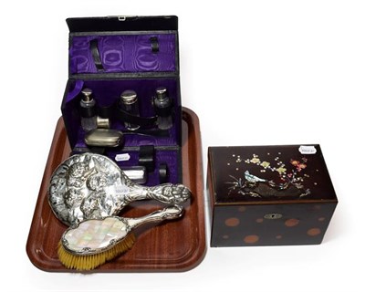 Lot 305 - A travelling silver plated dressing table set, a silver backed hand cherub hand mirror and a silver
