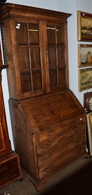 Lot 1231 - A Georgian style oak bureau bookcase, twin glazed doors above four flap fitted interior, two...
