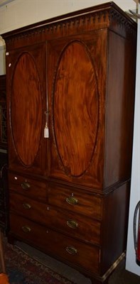 Lot 1241 - A George III mahogany linen press, moulded cornice above twin oval crossbanded panel doors, the...