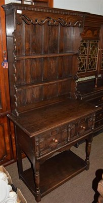 Lot 1242 - An 18th century style oak dresser, carved plate rack above base with twin moulded drawers,...