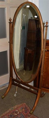 Lot 1245 - A mahogany cheval mirror, the oval bevelled plate on twin square tapered supports with urn finials