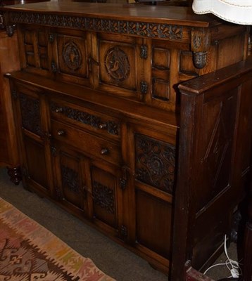 Lot 1253 - A 20th century oak court cupboard, heavily carved, twin central cupboards with profile...