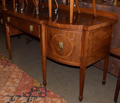 Lot 1259 - A George III mahogany and crossbanded bow front sideboard, single drawer flanked by cellarette...