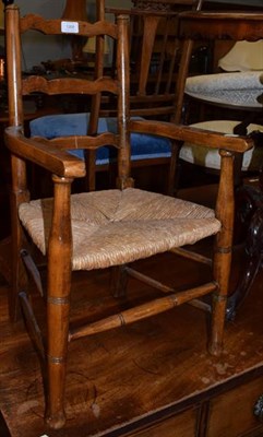 Lot 1268 - A child's rush seated ladder back armchair, 68cm high