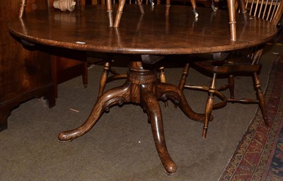 Lot 1274 - A Georgian style elm tilt top breakfast table, turned central column and four out swept legs,...