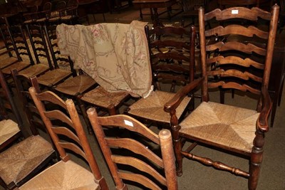 Lot 1290 - A set of nine rush seated ladder back chairs, including two carvers (9)