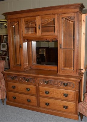 Lot 1404 - A large early 20th century oak mirrored back bookcase, three glazed cabinets above base with...