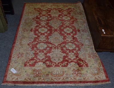 Lot 1449 - Afgan Rug, the strawberry field of stylised flower heads framed by floral borders, 178cm by 129cm