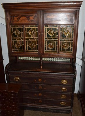 Lot 1455 - An Aesthetic glazed cabinet containing four drawers and a tiled back, the glazed door panels...