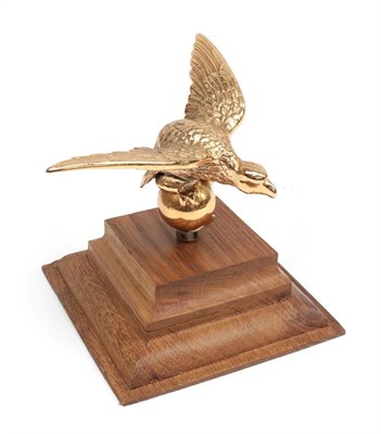 Lot 2034 - A Gilded Metal Car Mascot as a Winged Eagle, possibly from an Alvis, mounted on a graduated oak...