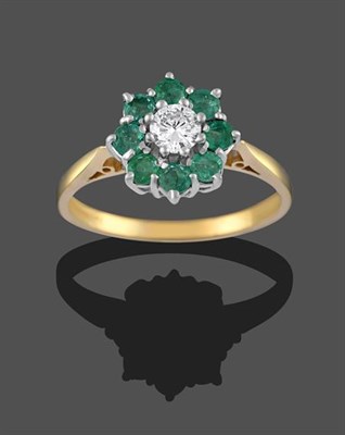 Lot 2144 - An 18 Carat Gold Emerald and Diamond Cluster Ring, the round brilliant cut diamond within a...