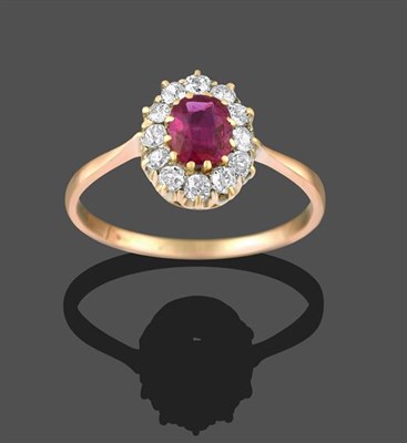 Lot 2153 - A Ruby and Diamond Cluster Ring, the oval cut ruby within a border of old cut diamonds, in...