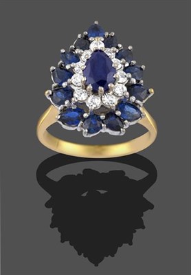Lot 2154 - A Sapphire and Diamond Cluster Ring, the pear cut sapphire within a border of eight-cut...