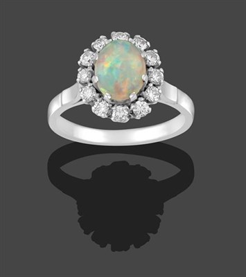 Lot 2174 - An Opal and Diamond Cluster Ring, the oval cabochon opal within a border of round brilliant cut...