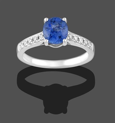 Lot 2179 - A Sapphire and Diamond Ring, the oval cut sapphire in a white claw setting to round brilliant...