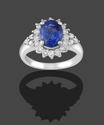 Lot 2182 - A Sapphire and Diamond Cluster Ring, the oval cut sapphire within a border of round brilliant...