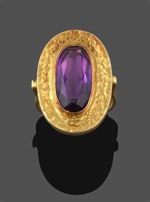Lot 2188 - An Amethyst Ring, the oval cut amethyst in a yellow rubbed over setting extending to a textured...