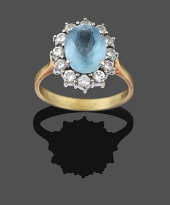 Lot 2199 - An 18 Carat Gold Aquamarine and Diamond Cluster Ring, the oval cut aquamarine within a border...