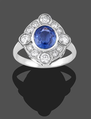 Lot 2212 - A Sapphire and Diamond Cluster Ring, the oval cut sapphire within a border of round brilliant...
