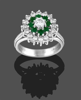 Lot 2215 - An 18 Carat White Gold Emerald and Diamond Cluster Ring, the central round brilliant cut...