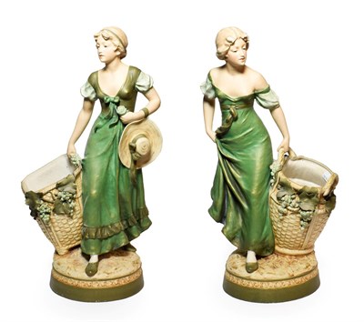 Lot 100 - A Pair of Royal Dux Bisque Porcelain Figures of Maidens, early 20th century, loosely dressed...