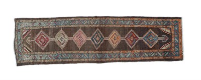 Lot 210 - North West Persian Runner, circa 1910 The camel ground with a column of stepped medallions...